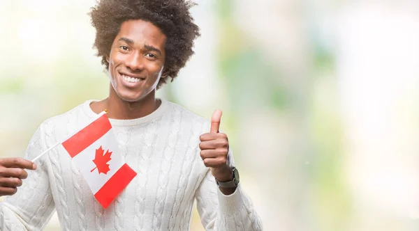 分離背景 サインをする笑顔と幸せにカナダの国旗をアフロ アメリカ人は優秀な兆候の指で親指 — ストック写真