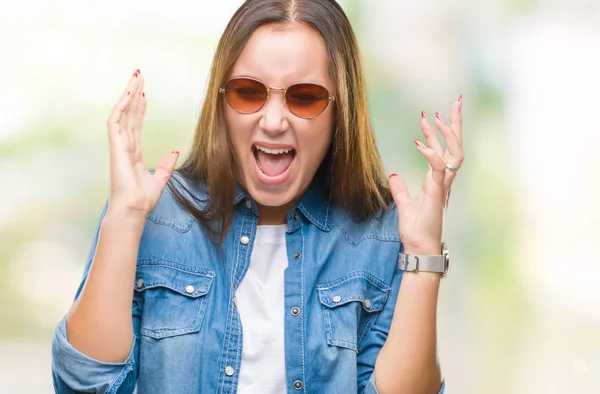 若い美しい白人女性のサングラスは狂気を祝う背景を分離し 腕の成功のため驚いて叫んで興奮発生と開いた目 勝者の概念 — ストック写真