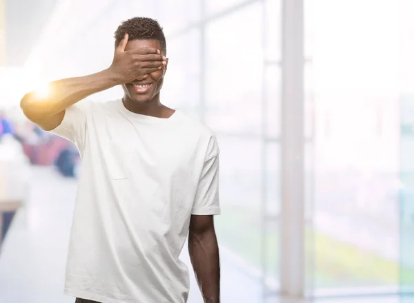Молодой Африканский Американец Белой Футболке Улыбается Смеется Закрывая Глаза Рукой — стоковое фото