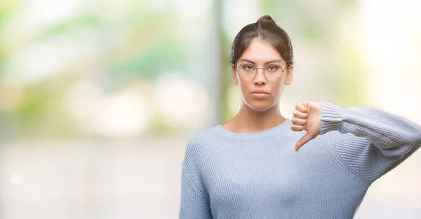 年轻漂亮的西班牙裔妇女带着愤怒的脸 消极的迹象显示不喜欢拇指下来 拒绝概念 — 图库照片