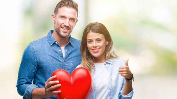 Giovane Coppia Innamorata Tenendo Cuore Rosso Sfondo Isolato Felice Con — Foto Stock