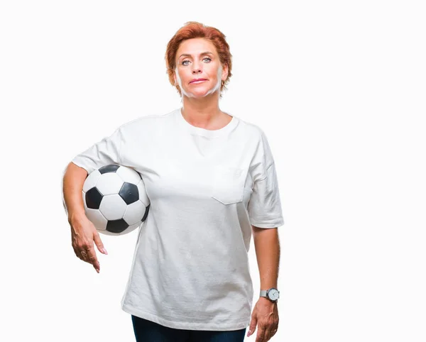 スマートの顔は深刻な思考に自信を持って式に分離された背景にサッカー ボールを保持している館白人赤毛の先輩女性 — ストック写真