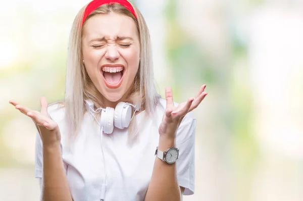 Молодая Блондинка Наушниках Слушает Музыку Изолированном Фоне Празднуя Безумный Безумный — стоковое фото