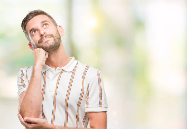 あごを考えて質問 物思いにふける式の手で隔離された背景に若いハンサムな男 思いやりのある顔をして笑っています 疑いのコンセプト — ストック写真