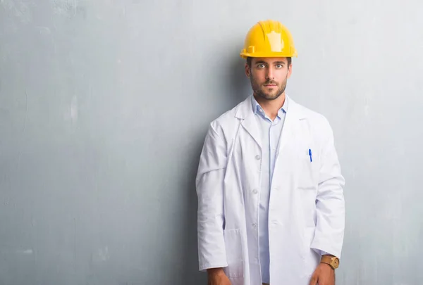 Bonito Jovem Engenheiro Homem Sobre Parede Grunge Cinza Usando Capacete — Fotografia de Stock