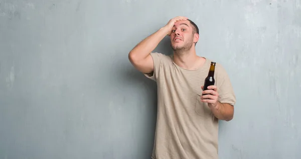 Young Caucasian Man Grey Grunge Wall Holding Bottle Beer Stressed — Stock Photo, Image