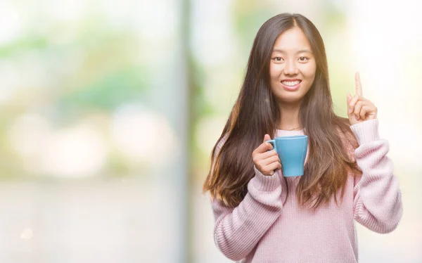 年轻的亚洲妇女喝咖啡在孤立的背景 — 图库照片