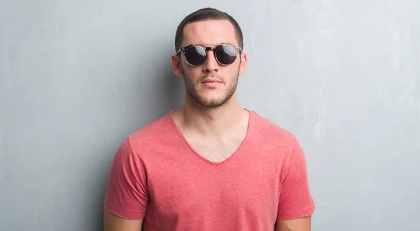 Junger Kaukasischer Mann Über Grauer Grunge Wand Mit Sonnenbrille Und — Stockfoto