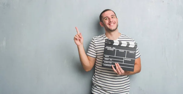 Young Caucasian Man Grey Grunge Wall Holding Movie Clapboard Very — Stock Photo, Image