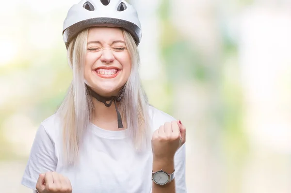 年轻的金发碧眼的女人戴着自行车安全头盔在孤立的背景非常高兴和兴奋做冠军手势举起双臂 面带微笑 尖叫着要成功 庆祝理念 — 图库照片