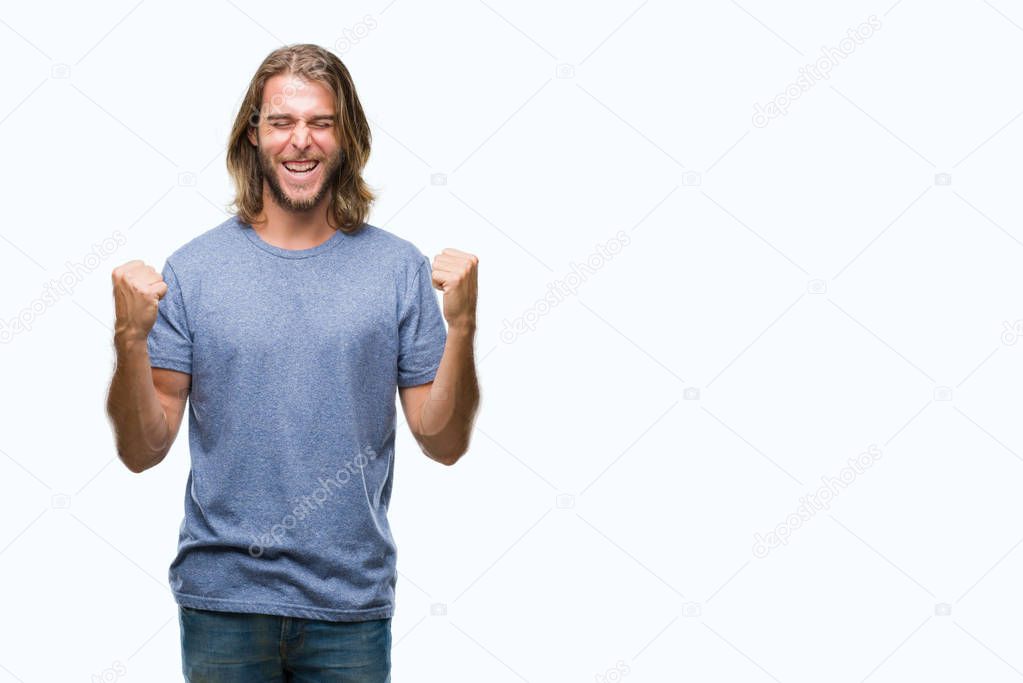 Young handsome man with long hair over isolated background very happy and excited doing winner gesture with arms raised, smiling and screaming for success. Celebration concept.