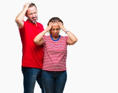 Orta yaş İspanyol çift aşık çünkü umutsuz ve stresli baş ağrısı acı izole arka plan üzerinde ağrı ve migren. Ellerini kafasına.