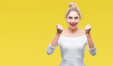 Kadın kutluyor izole arka plan üzerinde şaşırttı ve başarı için kaldırdı kollarını açarak hayret ve gözleri açık genç güzel sarışın ve mavi gözler. Kazanan kavramı.