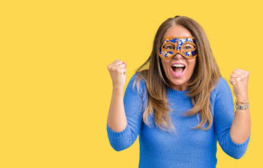 İzole arka plan kutlama üzerine Venedik karnaval maskesi giyen güzel orta yaş kadın şaşırttı ve başarı için kaldırdı kollarını açarak hayret ve gözleri açık. Kazanan kavramı.