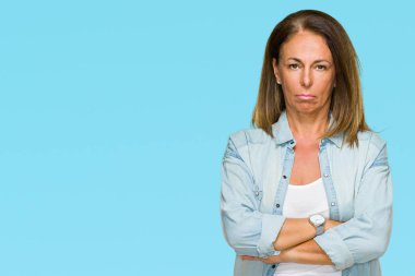 Orta yaş yetişkin kadın izole arka plan şüpheci ve sinir, onaylamayan ifade yüz çapraz kolları üzerinde rahat kot gömlek giymiş. Negatif kişi.