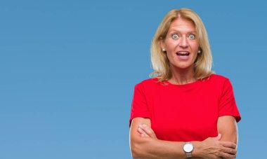 Orta yaş sarışın kadın izole arka plan korkuyor ve sürpriz ifade ile şok yüzünden korku ve yüz heyecanlı.