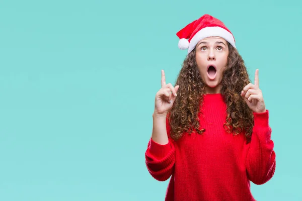 Jovem Morena Usando Chapéu Natal Sobre Fundo Isolado Espantado Surpreso — Fotografia de Stock