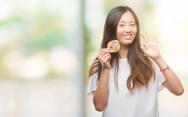 Joven Asiático Mujer Comer Chocolate Chip Cookie Sobre Aislado Fondo —  Fotos de Stock