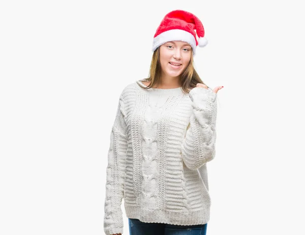 探していると親指側に上向きの幸せそうな顔を浮かべて隔離された背景にクリスマスの帽子をかぶって若い美しい白人女性 — ストック写真