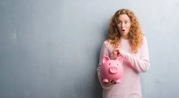 Jonge Roodharige Vrouw Grijs Grunge Muur Holding Piggy Bank Dollar — Stockfoto