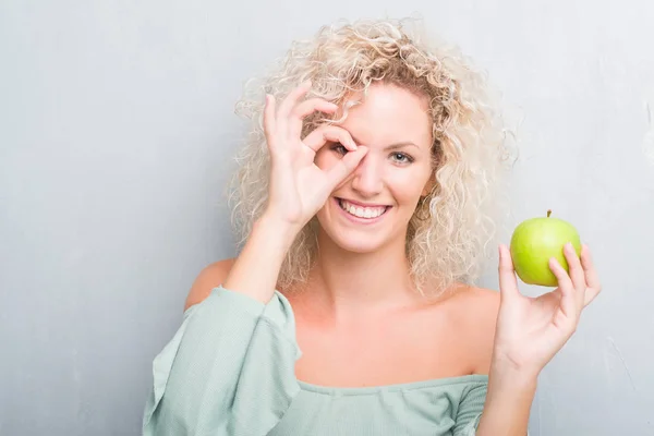 Giovane Donna Bionda Sfondo Grigio Grunge Mangiare Mela Verde Con — Foto Stock