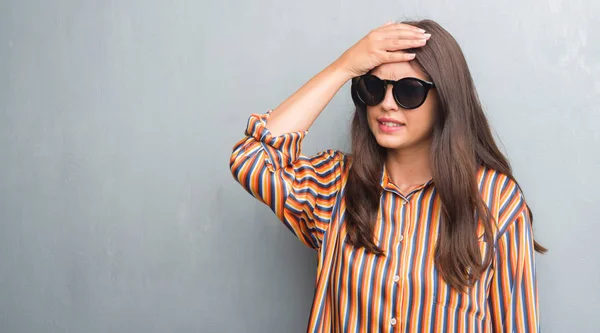 Junge Brünette Frau Über Grunge Grauer Wand Mit Großer Sonnenbrille — Stockfoto