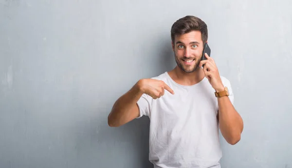 Guapo Joven Sobre Gris Pared Grunge Hablando Por Teléfono Con —  Fotos de Stock