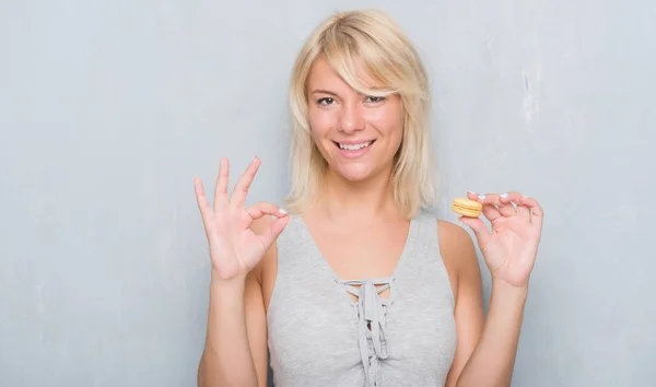 Erwachsene Kaukasische Frau Über Grunge Grey Wall Eating Macaron Doing — Stockfoto