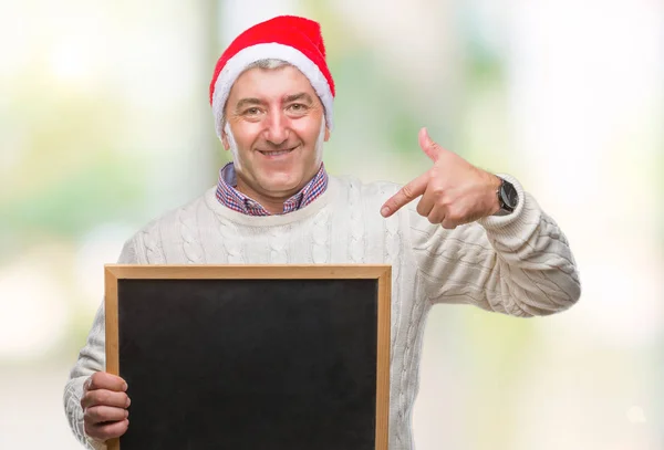 Bonito Homem Sênior Vestindo Chapéu Natal Segurando Quadro Negro Sobre — Fotografia de Stock