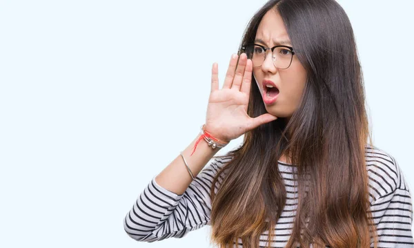 年轻的亚洲妇女戴着眼镜 在孤立的背景下大声喊叫 一边用手在嘴上尖叫 沟通理念 — 图库照片
