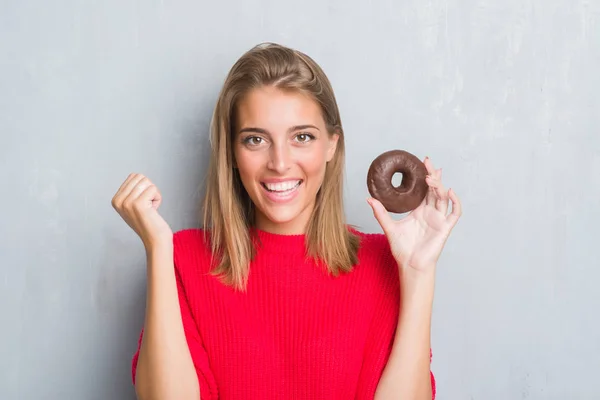 Hermosa Joven Sobre Pared Gris Grunge Comiendo Donut Chocolate Gritando —  Fotos de Stock