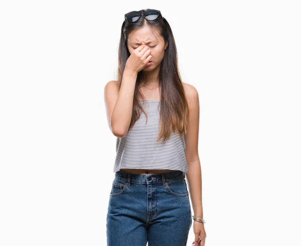 孤立した背景の上にサングラスをかけている若いアジア女性は ラビング鼻と目の疲労や頭痛を感じに疲れています ストレスと欲求不満のコンセプト — ストック写真
