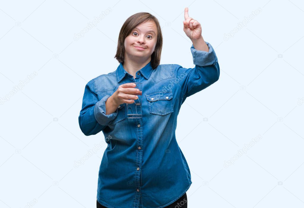 Young adult woman with down syndrome drinking water over isolated background surprised with an idea or question pointing finger with happy face, number one