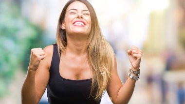 Gülümseyen ve başarı için çığlık genç güzel kadın izole arka plan çok mutlu ve heyecanlı kaldırdı, silah ile kazanan jest yapıyor. Kutlama kavramı.