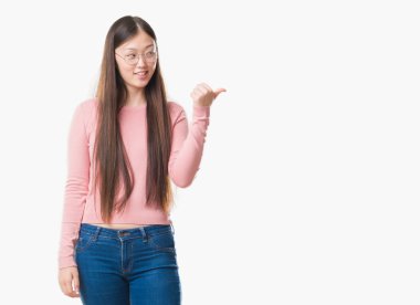 Arka plan seyir ve başparmak yanında yukarıyı mutlu yüz ile gülümseyen gözlüklü Genç Çinli kadın izole.