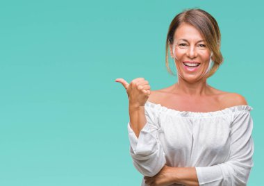 Orta yaş arıyor ve başparmak yanında yukarıyı mutlu yüz ile gülümseyen izole arka plan üzerine İspanyol kadın kıdemli.