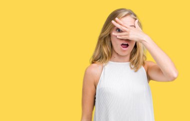 Yüz ve gözler el ile kapsayan şok bakmak izole arka plan üzerinde güzel genç zarif kadın mahcup ifadeyle parmaklarımın arasından arıyorsunuz.