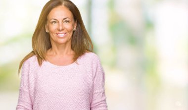 Yüzünde mutlu ve güzel bir gülümseme ile izole arka plan üzerinde kış kazak giyen güzel orta yaş yetişkin kadın. Şanslı kişi.