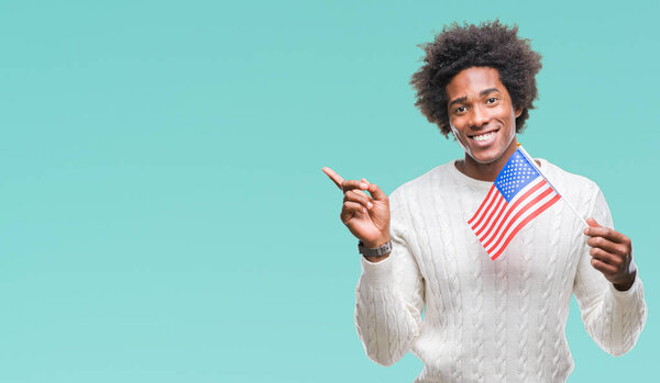 Afro american man flag of United States of America over isolated background very happy pointing with hand and finger to the side