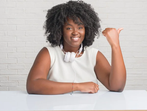 Unga Afroamerikanska Kvinnan Sitter Bord Bär Hörlurar Leende Med Glada — Stockfoto