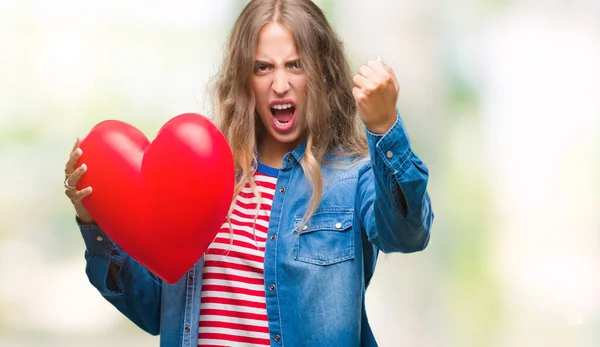 Linda Jovem Loira Segurando Coração Valentine Sobre Fundo Isolado Irritado — Fotografia de Stock