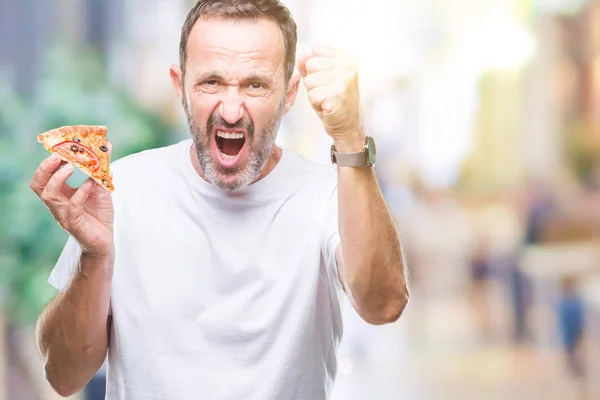 中年老人吃比萨饼切片在孤立的背景恼怒和沮丧的呼喊与愤怒 疯狂和叫喊与举手 愤怒的概念 — 图库照片