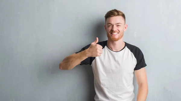 Young Redhead Man Grey Grunge Wall Doing Happy Thumbs Gesture — Stock Photo, Image