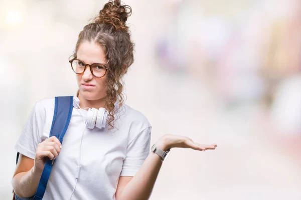 Junge Brünette Studentin Mit Rucksack Und Kopfhörer Über Isoliertem Hintergrund — Stockfoto