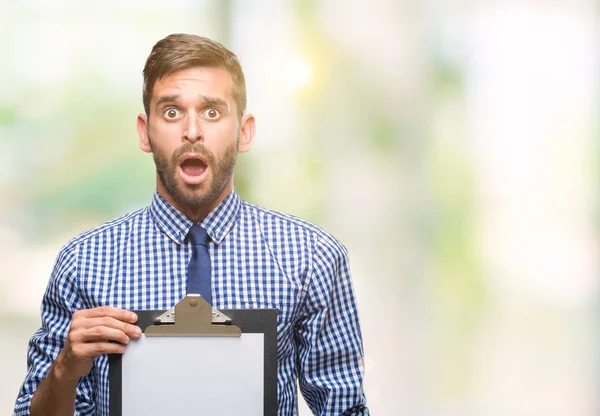 Junger Gutaussehender Geschäftsmann Der Klemmbrett Über Isolierten Hintergrund Hält Erschrocken — Stockfoto