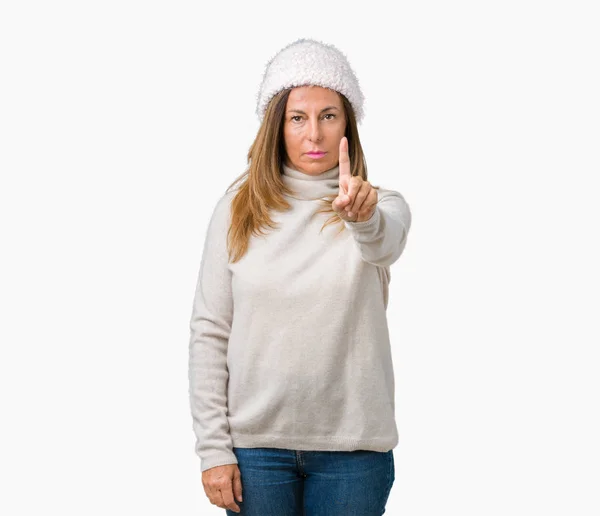 美丽的中年妇女穿着冬季毛衣和帽子在孤立的背景指向用手指和愤怒的表情 — 图库照片