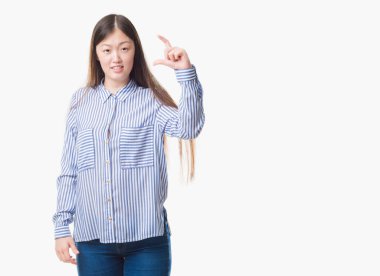 İzole arka plan gülümseyen ve süre seyir ve kamera boyutu işaret parmaklarıyla yapıyor el ile kendinden emin eller genç Çinli kadın. Ölçü kavramı.