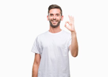 Gülümseyen izole arka plan üzerinde genç yakışıklı adam el ve parmaklar ok işaretiyle yapıyor olumlu. Başarılı ifade.