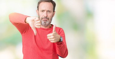 İzole arka plan yapmaya başparmak yukarı ve aşağı, anlaşmazlık ve anlaşma ifade üzerinde kış kazak giymiş yakışıklı orta yaş ağarmış komuta sizde. Deli çatışma