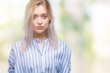 Genç Sarışın kadın yüzünde ciddi bir ifade ile izole arka plan yüzünden. Basit ve doğal kameraya bakıyor.